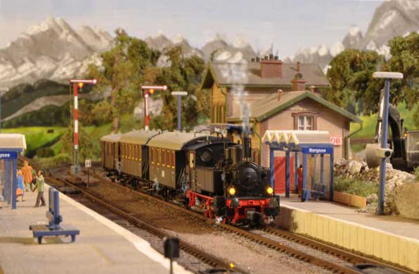 Die FLEISCHMANN 98 812 wartet mit dem Museumszug im Bahnhof Bergsee auf Weiterfahrt. Die Dampffahnen an Kamin, unter den Zylindern und zwischen den Wagen sind in das Bild hineinretuschiert.